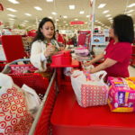 TINA Paul, left, signs for her transaction as Target employee Josephine Silverster looks on at a Target Corp. store in Colma, Calif. / BLOOMBERG NEWS FILE PHOTO DAVID PAUL MORRIS