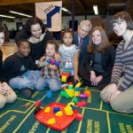 BANKNEWPORT VICE PRESIDENT and Newport Branch Manager Jennifer Pratt (seated, second from right) joined Baby Steps President Dr. Charles Shoemaker (kneeling, center) for a recent Baby Steps session for children and parents held at the Florence Gray Center in Newport. Ydalis Perez and her three children were enjoying the interactive activities with Bradley School representatives, Rebecca Berger (kneeling left) and Rochelle Fritz (kneeling right). / COURTESY BANKNEWPORT