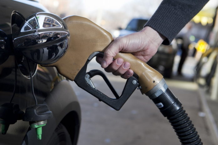 A FUEL nozzle is placed into a vehicle at a filling station in this arranged photo in Washington, D.C.,  / BLOOMBERG NEWS FILE PHOTO/ANDREW HARRER