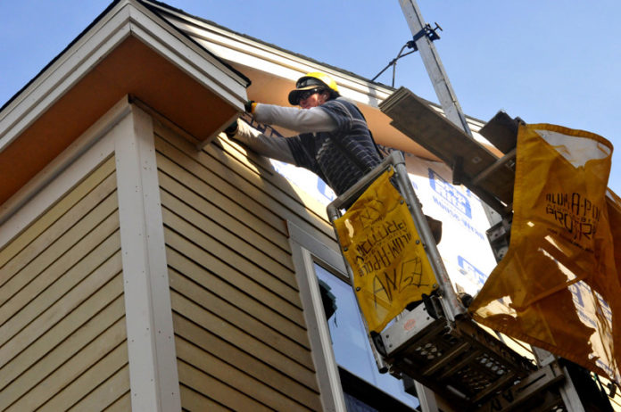 COMING HOME: A worker with Stand Corporation finishes a renovation at 61 Camden Ave. in Providence. For the first time in years, renovated homes outnumber newly abandoned ones in the neighborhood thanks in part to efforts to rehab foreclosed properties. / PBN PHOTO/FRANK MULLIN