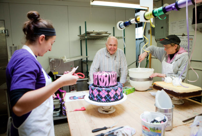 TAKING THE CAKE: LaSalle Bakery owner Michael Manni has watched the business grow since he purchased it 37 years ago. Above, he's pictured with employees Nicole Dellagiovanna, left, and Paula De Certis. / PBN PHOTO/RUPERT WHITELEY