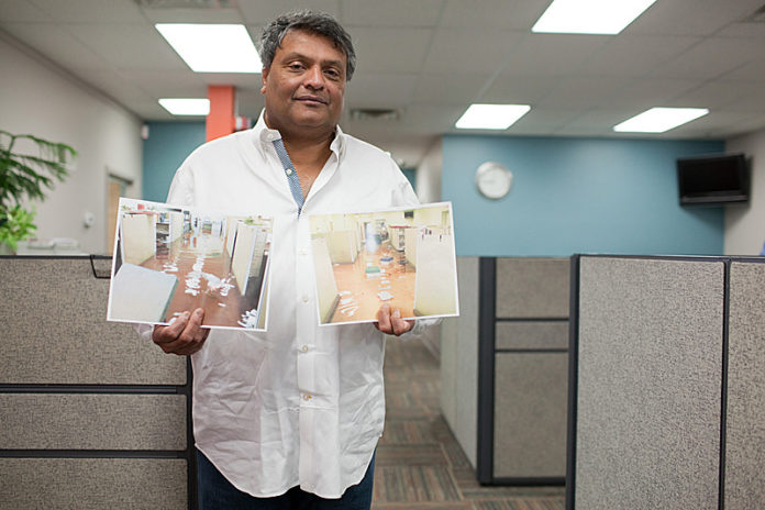 BELOW WATER: Shanix Technology owner Kehin Shah holds photos of the damage in his Cranston office caused by the March 2010 floods. Like many small-business owners at the time, Shah did not have flood coverage. / PBN PHOTO/RUPERT WHITELEY