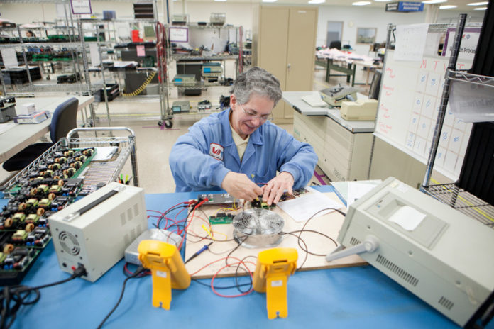 SERVICE AFTER SACRIFICE: John Shepard, a Vietnam combat veteran, created Veterans Assembled Electronics to offer free technical training in electronics diagnostics for veterans across the country. Pictured above is Mary Lou Clark, an assembly technician with Veterans Assembled. / PBN PHOTO/RUPERT WHITELEY