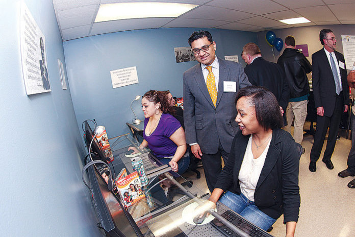 GTECH CORP. President and CEO Jaymin B. Patel watches as students try out the computers at Family Resources Community Action’s new After School Advantage computer lab. The lab is the 174th opened by GTECH nationwide since launching the After School Advantage program in 1999.