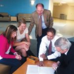 Bryant program connecting business students to jobs HANDS-ON EXPERIENCE: Bryant University students Alicia Kennedy, left, and Makena Sage with Gerald Cohen, standing, Chafee Center for International Business trade specialist, Madan Annavarjula, second from right, Bryant international business program director and David Marquis, president of ChemArt. / COURTESY BRYANT