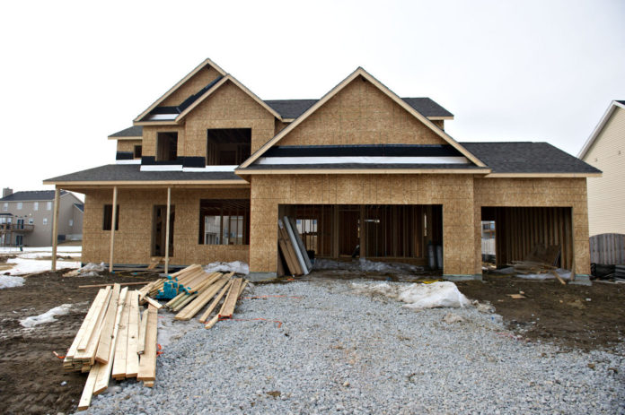 BUILDER CONFIDENCE in the market for newly built, single-family home reached the highest reading since May 2007, according to the National Association of Home Builders. Lumber sits outside a partially completed single-family home under construction in Bloomington, Ill. / BLOOMBERG FILE PHOTO/DANIELACKER