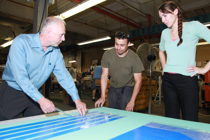 MAKING IT WORK: PolyWorks, founded in 2003, has tripled its workforce in the past five years. Above, from left, Roger LaFlamme, 
co-owner and executive vice president, works with employees Albert DeLeon, team leader, and Lola Objois, quality/process engineer. / PBN PHOTO/NATALJA KENT
