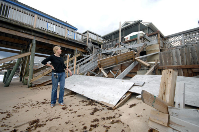 LIFE'S A BEACH: Tara Mulroy, owner of Tara's Tipperary Tavern, surveys her business' damaged beach deck. Her lawyer says she is seeking options to protect the business. / PBN PHOTO/BRIAN MCDONALD
