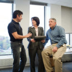 Navigating a path to success by collaboration GETTING IT DONE: Textron’s Marie Carlino has a reputation at the diversified manufacturer for making sure that her assignments are done and done right. With her are Al Gutierrez, left, a sytems specialist, and Russel Marceau, a systems manager, at the company’s Providence headquarters. / PBN PHOTO/RUPERT WHITELEY