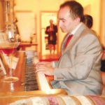 COURTESY AMY REINHOLTZ
BANDWIDTH BLUES: Joel Tenenbaum plays the piano for friends at his apartment in Boston. The 28-year-old is facing nearly $700,000 in owed damages to Sony BMG Music Entertainment.