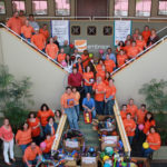 At Embrace Home Loans,
wear jeans, do good GROUP EFFORT: Orange Day 2011, when Embrace Home Loans employees donated sporting goods to local schools and nonprofits, was held on the company’s 28th anniversary in business. / Courtesy
Embrace Home Loans