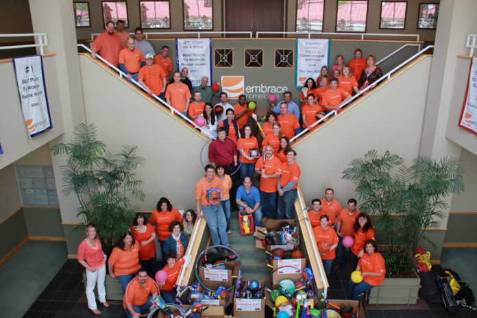 GROUP EFFORT: Orange Day 2011, when Embrace Home Loans employees donated sporting goods to local schools and nonprofits, was held on the company’s 28th anniversary in business. / Courtesy 
Embrace Home Loans