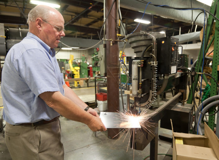 GETTING A GRIP: Gripnail Corp. President David Ashton has recently worked with the Chafee Center for International Business in an attempt to expand his business into Middle East. Above, he demonstrates some of his company's machinery. / PBN PHOTO/CATIA CUEN