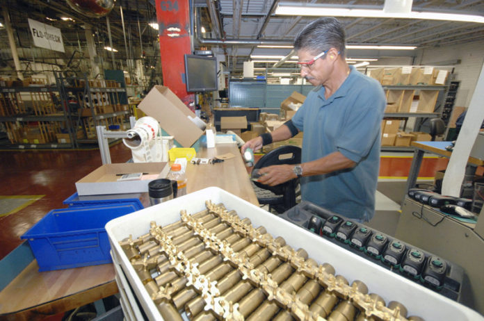 BUILDING BLOCKS: Taco Inc. has managed to significantly grow its business through increased efficiency and use of new technology by employees such as Guillermo Lugo, above, packing pumps for shipment. / PBN PHOTO/BRIAN MCDONALD