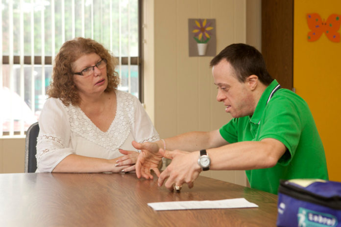 ALL ACCESS: Cathy Silva, program director of AccessPoint RI, talks with volunteer Brian Imondi. AccessPoint will host a URI program funded with a $14 million grant. / PBN PHOTO/DAVID LEVESQUE