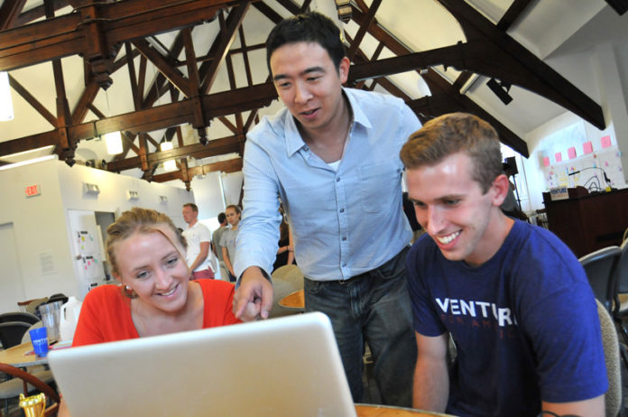 BRIDGING THE GAP: Andrew Yang, center, speaks with Melanie Friedrichs and Sean Lane during a Venture for America meeting at Brown University. The career-training program looks to eliminate the so-called skills gap some graduates and firms wrestle with. / PBN PHOTO/FRANK MULLIN