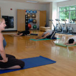 DOWNWARD FACING AND HEALTHIER: Bryna Rene instructs a yoga class at Bryant University as part of the wellness-center programming on campus. / PBN PHOTO/BRIAN MCDONALD