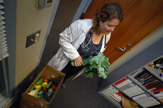 FARM FRESH: Nurse Practitioner Rachel Roach picks up her fresh vegetables – part of a R.I. Department of Health program – at University Medicine at Rhode island Hospital. / PBN PHOTO/
BRIAN MCDONALD