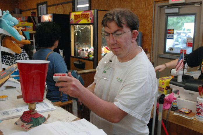 HAPPY CAMPERS: Christopher Craig prices batteries at the Burlingame state park store. / PBN PHOTO/BRIAN MCDONALD