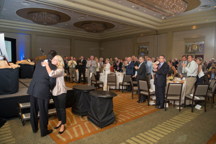 SOFIA CAPRIA receives a hug after sharing her story with those who attended the New England Public Service Award Luncheon. Capria was a client of Phoenix House, to which the Taco/White Family Foundation recently granted $25,000.
