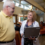 Health clinics gird for patient boom QUALITY CARE: Lawrence T. Geary, a patient at Thundermist Community Health Center, speaks to medical assistant Jill Antunes in the lobby of the newly renovated Quick Care Center in West Warwick. / PBN PHOTO/NATALJA KENT