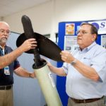 KEEPING IT SIMPLE: Sea Corp. program manager Barry Holland, left, and Vice President of Corporate Development Richard Talipsky demonstrate one of the launch tubes the company improved. / PBN PHOTO/RUPERT WHITELEY
