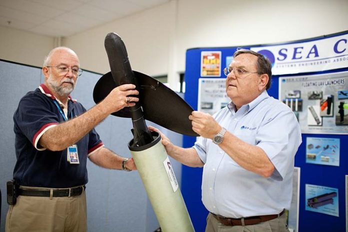 KEEPING IT SIMPLE: Sea Corp. program manager Barry Holland, left, and Vice President of Corporate Development Richard Talipsky demonstrate one of the launch tubes the company improved. / PBN PHOTO/RUPERT WHITELEY