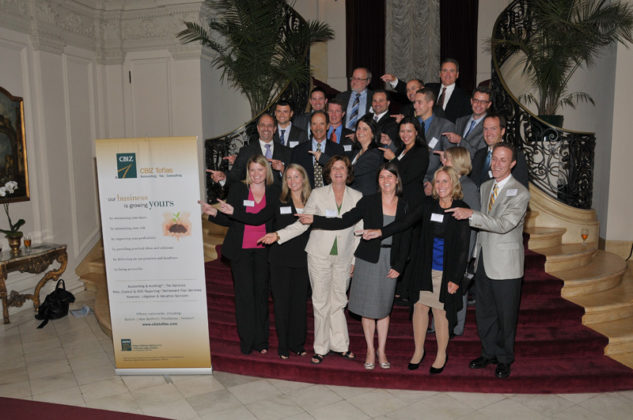 Executives from presenting sponsor CBIZ Tofias gather on the red carpeted stairs at Rosecliff / Skorski Photography