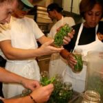 FRESH IDEAS: Harvest Kitchen Program Coordinator Ryan Reeves, left, helps trainee workers pickle beans at the United Methodist Church kitchen in downtown Providence. / PBN PHOTO/MICHAEL PERSSON