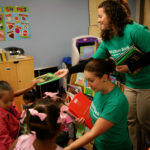 DELIVERING THE GOODS: Citizens Bank employees hand out books collected from co-workers to pupils at Children&rsquo;s Friend. / PBN PHOTO/MICHAEL PERSSON