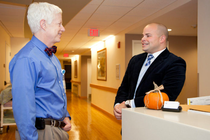 PROVIDING CARE: Charles P. Iacono, right, vice president of philanthropy at Home and Hospice Care of Rhode Island, speaks with Dr. Edward Martin, chief medical officer at the nonprofit. Iacono says he’s seen increased support from corporations recently. / PBN PHOTO/NATALJA KENT