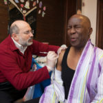 SHOT IN THE ARM: Warwick resident Simon Davis gets a flu shot from Dr. Michael Fine, director of the R.I. Department of Health, during a recent flu clinic at Cathedral of Life Christian Assembly in Providence. Fine says about 40 percent of R.I. residents get vaccinated against the flu. / PBN PHOTO/DAVID LEVESQUE