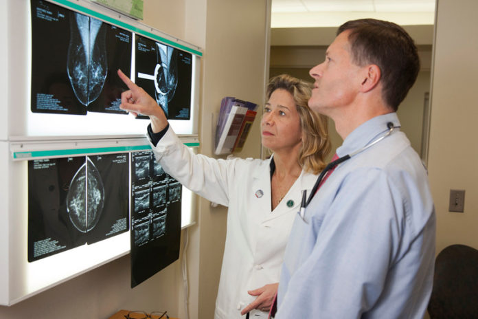OUT IN FRONT: Dr. Jennifer Gass, an oncology surgeon at the Breast Health Center at Women & Infants’ Program in Women’s Oncology, reviews medical images with Dr. Robert D. Legare, medical director for the Breast Health Center. / PBN PHOTO/DAVID LEVESQUE