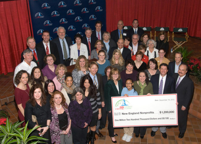 Seventy-seven nonprofits received a welcomed holiday-season boost Dec. 19, sharing $1.2 million generated from the 2012 CVS Caremark Charity Classic. PGA tour professionals and tournament co-hosts Brad Faxon, second row, fourth from left, and Billy Andrade, first row, second from right, joined CVS Caremark President and CEO Larry Merlo, first from right, at the presentation at CVS Caremark headquarters. / PHOTO COURTESY CVS CAREMARK