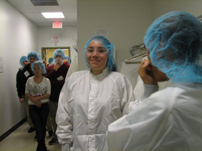 Alondra Perez, middle, and fellow Woonsocket High School biotech-program students don clean suits and protective eyewear as they prepare to enter C.R. Bard’s Davol facility in Warwick. Twenty-four students from the program received firsthand looks and insight into various aspects of the medical-device field during the Dec. 5 tour. Davol is a wholly owned subsidiary of C.R. Bard, Inc. / COURTESY TECH COLLECTIVE