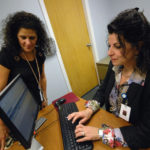 SHINING LIGHT: Cheryl Dumas, health and wellness coordinator and claims co-ordinator, seated, and Robyn Pingitore, claims coordinator, use the new fiber-optic computer system at Fatima Hospital in North Providence. / PBN PHOTO/BRIAN MCDONALD