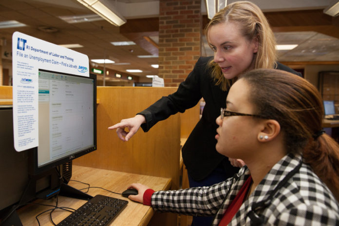 NET WORK: Corrie MacDonald, standing, a librarian at Cranston Public Library, works with Rhode Island College student Meury Inirio. / PBN PHOTO/DAVID LEVESQUE