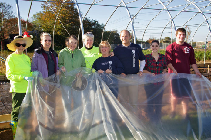 REPRESENTATIVES FROM BankNewport recently stopped by Methodist Community Gardens to assist volunteers in covering a new greenhouse that was funded through a $2,000 grant from the bank.