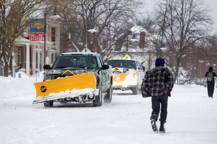 CLEAN-UP CONTINUES from winter storm Nemo, which dumped more than two feet of snow in parts of Rhode Island and Massachusetts this weekend. Above: Snow plows drive down Harvard Street after Winter Storm Nemo in Brookline, Mass., on Saturday, Feb. 9. / BLOOMBERG FILE PHOTO/SCOTT EISEN