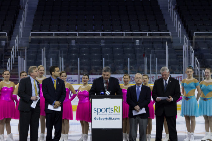 MEMBERS OF THE WARWICK Figure Skaters provide a backdrop for the announcement that Providence and Warwick will host the 2015 U.S. Synchronized Skating National Championships.  From left: RI Convention Center Authority Chairman Jim Bennett; Providence Mayor Angel Taveras; RI Sports Commission Executive Director John Gibbons; Warwick Figure Skaters Spokesman Don McKenzie and Warwick Mayor Scott Avedisian. / COURTESY THE R.I. SPORTS COMMISSION