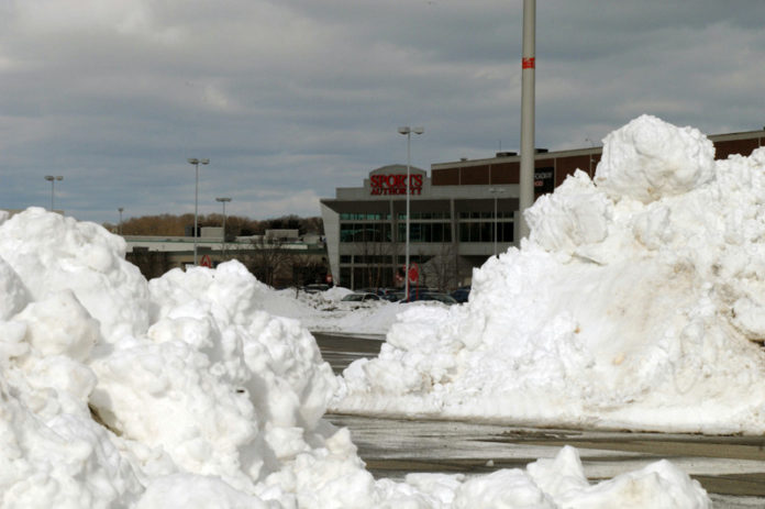 SHOVELING OUT: Closing early Friday, Feb. 8, in advance of the blizzard, Warwick Mall didn't open again until the following Sunday morning. One of the biggest challenges was clearing the shopping center's 5,000-space parking lot. / PBN PHOTO/BRIAN MCDONALD