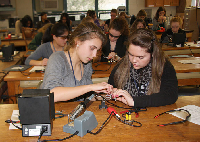 TWO HIGH SCHOOL students take part in a hands-on workshop at last year's GRRL Tech Expo, also held at the University of Rhode Island. / COURTESY TECH COLLECTIVE