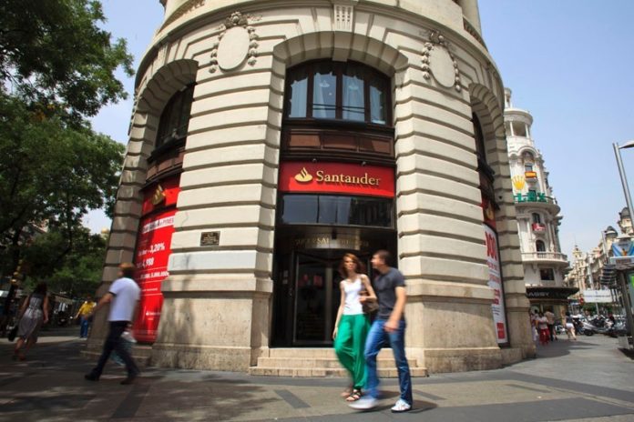 PAYING DIVIDENDS? Pedestrians pass the entrance to a Banco Santander SA branch in Madrid. The European bank purchased Sovereign Bancorp four years ago, a move that analysts say could help the parent company in the near future. / BLOOMBERG PHOTO/ANGEL NAVARRETE