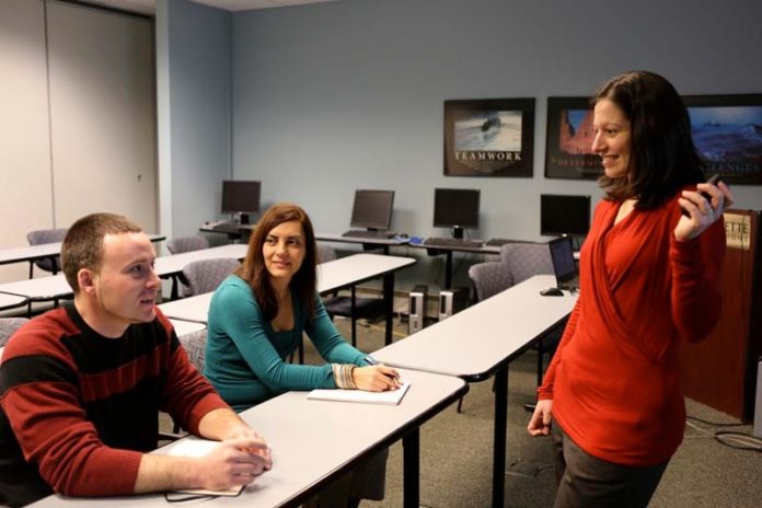TAKING FLIGHT: Two of Collette’s new hires: Fatima Karantonis, marketing consumer-intelligence analyst, and Jordan Loiselle, IT help-desk-support specialist, taking part in a training session run by company Director of Training Anna Tejada, standing. / COURTESY COLLETTE VACATIONS
