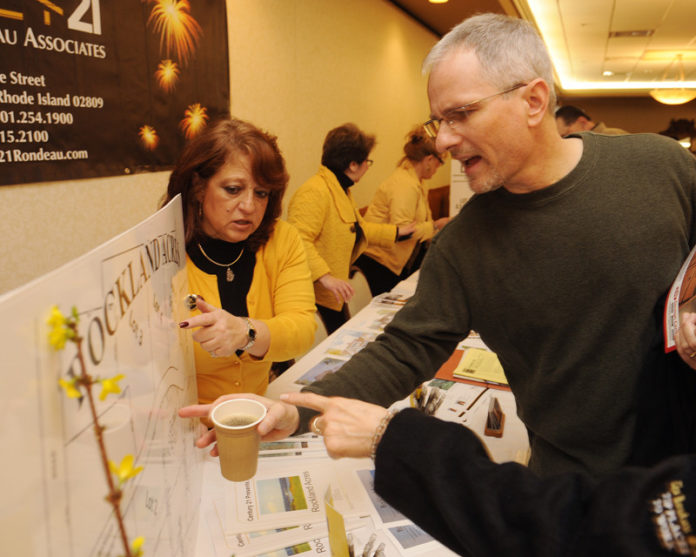 BUILDING SOMETHING: Roseann Dugan, Century 21 Rondeau Associates sales associate, talks with Roger Caberal of Acushnet at a Home Construction Expo organized by Bristol County Savings Bank. About 45 attendees came to the first of two expos held in early March. / PBN PHOTO/MARTIN GAVIN