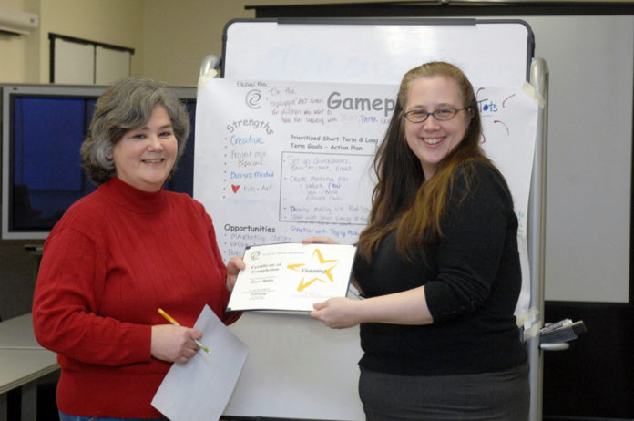 HER OWN BOSS: Lori Allen, right, Center for Women and Enterprise manager of corporate, foundation and government giving, gives a certificate of completion to Elaine Walle, who participated in a class at the center. / PBN PHOTO/BRIAN MCDONALD