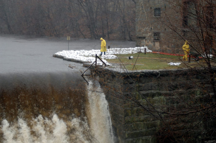 THE MARCH 2010 FLOODS put extra stress on many Rhode Island dams. The American Society of Civil Engineers report scored the state for not having any emergency action plans for its dams. Here, workers from Leslandes Construction work to ensure that the dam at Natick Mill does erode and fail due to rising water. / PBN FILE PHOTO/BRIAN MCDONALD THE MARCH 2010 FLOODS put extra stress on many Rhode Island dams. The American Society of Civil Engineers report scored the state for not having any emergency action plans for its dams. Here, workers from Leslandes Construction work to ensure that the dam at Natick Mill does erode and fail due to rising water. / PBN FILE PHOTO/BRIAN MCDONALD