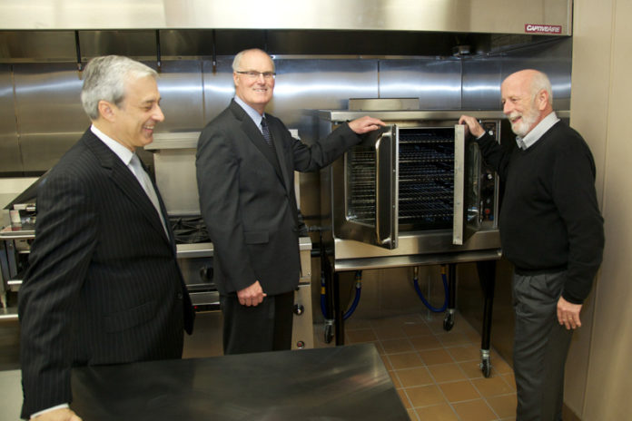 FROM LEFT: Dennis Algiere, a senior vice president with Washington Trust; Joseph J. MarcAurele, Washington Trust chairman, president and CEO; and Russell Partridge, executive director of the Warm Center, tour the newly constructed facility’s kitchen.