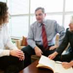 MOVING BEYOND THE NUMBERS: FM Global CFO Jeffrey Burchill is known to empower his team, including Joy Cave, left, assistant vice president, financial services, and Theresa Molloy, vice president, controller. / PBN PHOTO/RUPERT WHITELEY