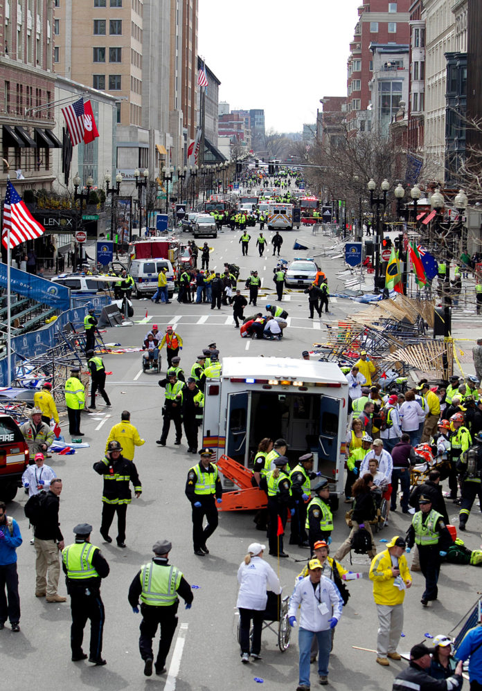 FIRST RESPONDERS tend to the wounded where two explosions occurred along the final stretch of the Boston Marathon on Boylston Street in Boston, Massachusetts, U.S., on Monday, Two powerful explosions rocked the finish line area of the Boston Marathon near Copley Square and police said many people were injured. / BLOOMBERG PHOTO/KELVIN MA FIRST RESPONDERS tend to the wounded where two explosions occurred along the final stretch of the Boston Marathon on Boylston Street in Boston, Massachusetts, U.S., on Monday, Two powerful explosions rocked the finish line area of the Boston Marathon near Copley Square and police said many people were injured. / BLOOMBERG PHOTO/KELVIN MA